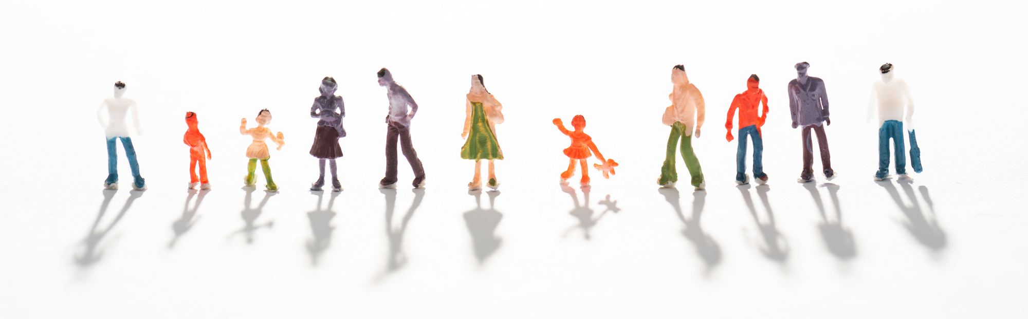 Panoramic shot of people figures on white surface with shadow