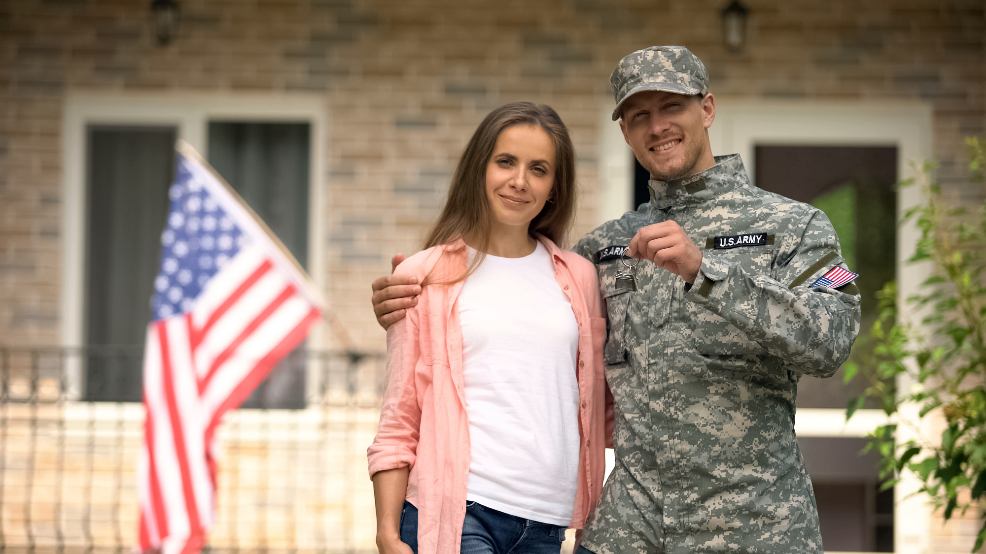 Soldier and wife showing keys from new house, government social insurance